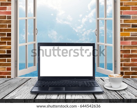Laptop with blank screen and coffee cup on table 