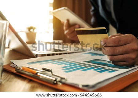 Business man hands using laptop,tablet and holding credit card with digital layer effect diagram as Online shopping concept
