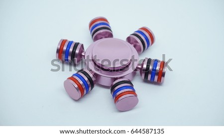 A pink metal hand spinner. Fidget for increased focus, stress relief in an isolated white background.
