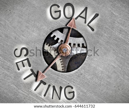 Macro photo of pointer and tooth wheel mechanism with GOAL SETTING letters imprinted on metal surface
