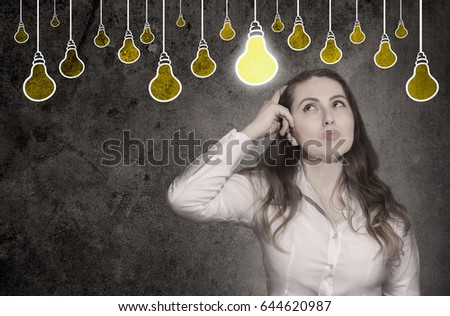 Thinking woman looking up with light idea bulb above head isolated on gray 