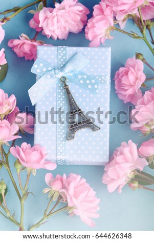 Romantic background. Eiffel tower miniature with gift box and roses.
