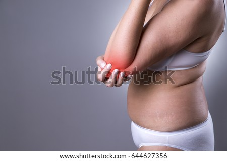 Pain in joint, care of female hands, ache in woman's body on gray background