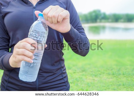 Close-up plastic water bottle in woman hand After Exercise Royalty-Free Stock Photo #644628346