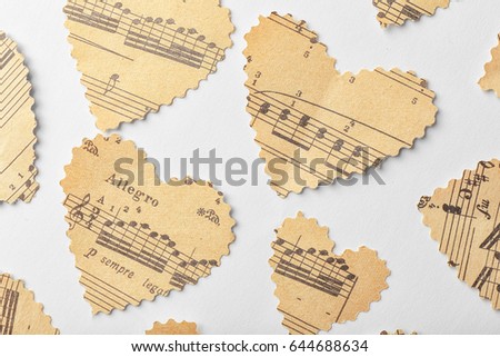 Paper hearts with notes on white background, music concept