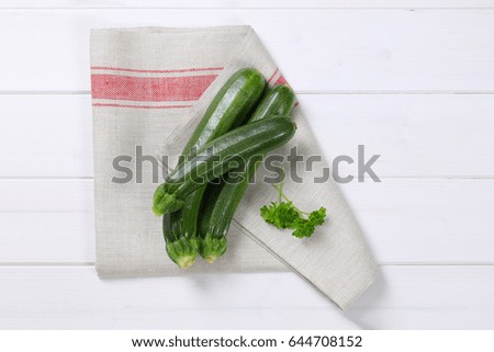 fresh green zucchini on folded dishtowel