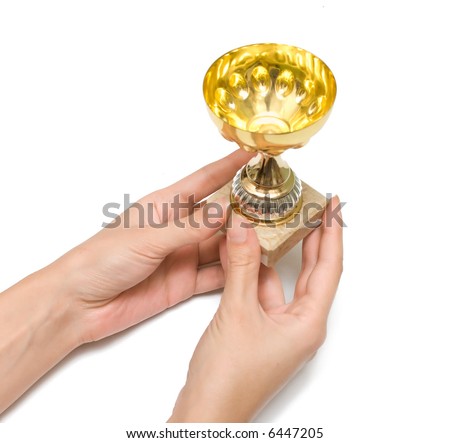 Female hands stretch a cup to the winner. A white background.