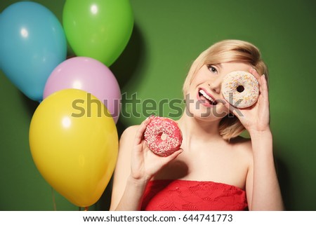 Beautiful woman holding donuts on green background