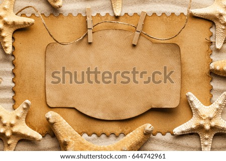 Starfishes and blank paper sheet on beach sand