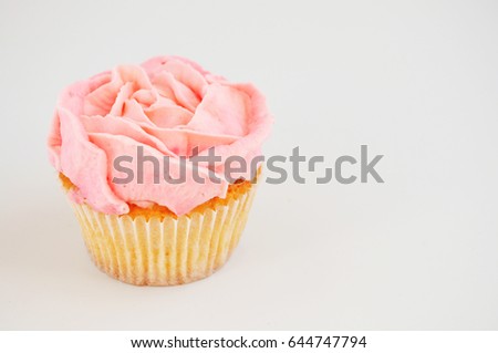Cupcake with pink cream rose flower on white background. Picture for a menu or a confectionery catalog.