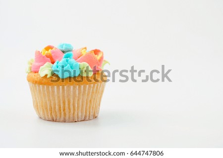 Cupcake with colorful cream flowers on white background. Picture for a menu or a confectionery catalog.