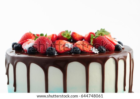 Birthday cake in chocolate with strawberries, blueberries and snowflake on white background. Close-up. Picture for a menu or a confectionery catalog.
