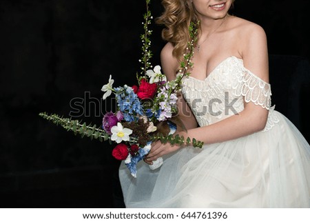 modern bridal bouquet in hands of bride with copy space on a dark background