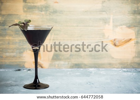 Black martini cocktail on the rustic background. Shallow depth of field.