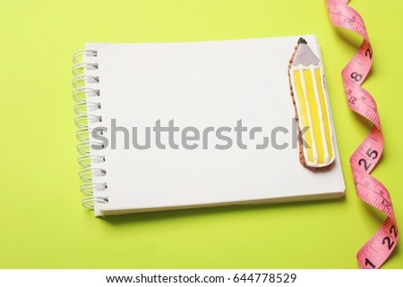 Diet control concept background.  Measuring tape  on  color background with book diary notepad and pen for healthy fitness .Space for text