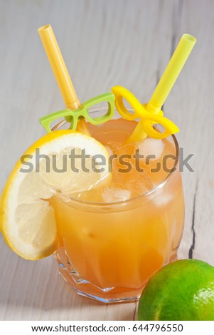 Cocktail with orange juice in a glass. Mint leaves. Lime. Lemon. Decoration and decoration. Cocktail straw. Glasses. Orange fresh with ice. Freshness. Cold drink. Thirst quenching. Alcohol Cocktail

