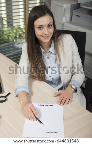 Business woman shows where to sign an empty contract