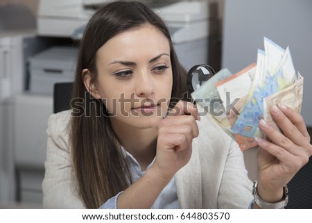 Business woman checking the authenticity of money