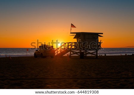 Sunset on California beach and lifeguard tower.