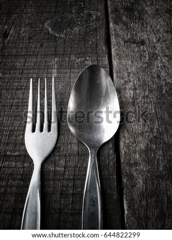 Spoon and fork on wood background