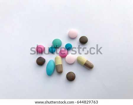Closeup Different kinds of medicine set on white background. Green ,pink,blue and brown pills with two-tone color capsule. Pharmaceutical concept. Selective focus with copy space.
