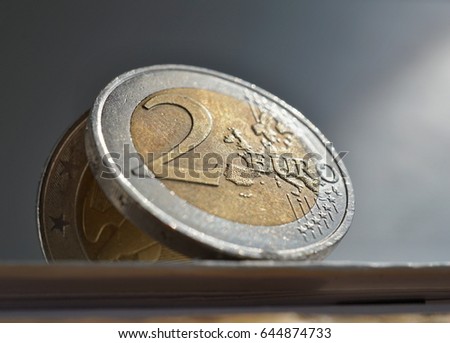 Macro detail of a silver and golden coin in value of two Euros (EUR, Euro) on white and silver background as a symbol of European currency
