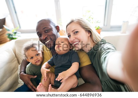 Young interracial family with little children taking selfie. Royalty-Free Stock Photo #644896936