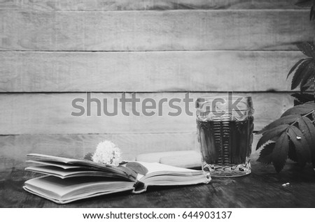 Flowers of mountain ash, aClose-up, selective focus, copyspace for text.n open book and a glass of tea on a wooden background. ?lack and white photography.