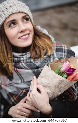 Young woman in a hat on a white pew with a bouquet of flowers tulips spring love