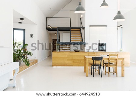 Spacious open kitchen with a dining room in a modern house Royalty-Free Stock Photo #644924518