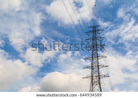 High voltage towers against a blue sky and beautiful clouds.