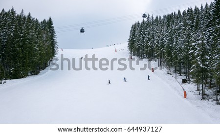 Skiers and snowboarders riding on a ski slope in Jasna Chopok in Slovakia ski resort.