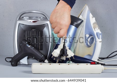 At the hands of men unplugged plugs to save on energy.Concept of energy saving Royalty-Free Stock Photo #644939041