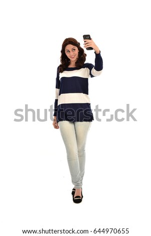 full length portrait of brunette girl wearing jeans and stripped top. isolated against white background.
  