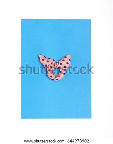 colorful dotted hair band or bracelet with bow isolated on blue and white background. Flat lay. Top view.