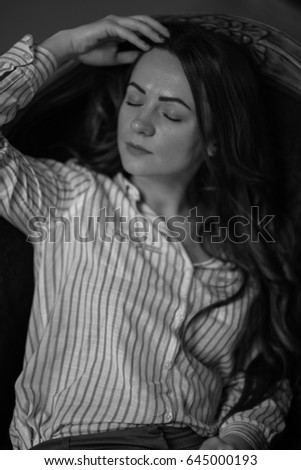 Portrait of elegant woman sitting on black sofa