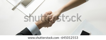Top view of a strong handshake between man and woman, both sides viewpoints and interests considered. Business concept photo. Horizontal photo banner for website header design with copy space for text