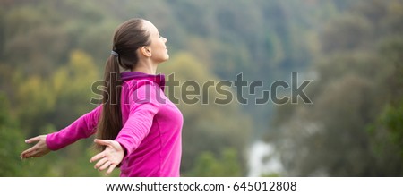 Portrait of an attractive woman outdoors in a sporstwear, her hands outstretched. Concept photo, side view. Horizontal photo banner for website header design 