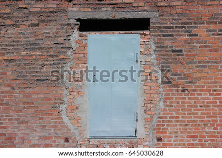 Iron door in the old brick wall