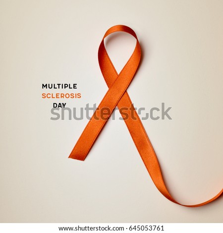 the text multiple sclerosis day and an orange ribbon on a beige background Royalty-Free Stock Photo #645053761