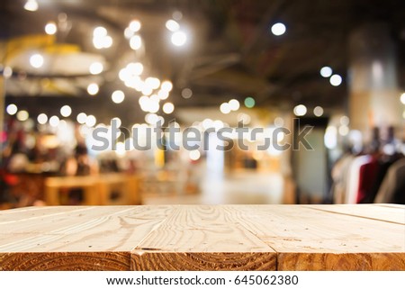 empty wooden table and blur department store with bokeh for background - template for product display montage and business presentation