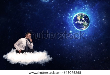Caucasian businessman sitting on a white fluffy cloud looking and wondering at planet earth