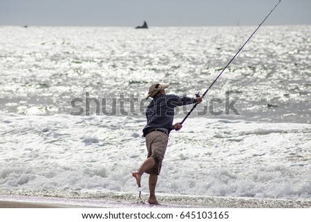 Man is fishing in the ocean.