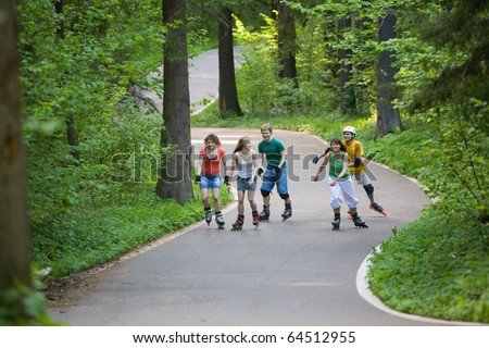 Group of men and women on rollerblades skating at park