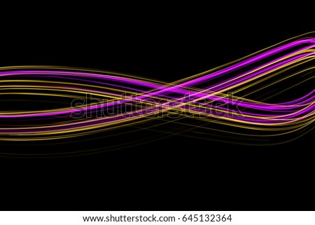 Pink and Gold Light Painting Photography, waves and ripples  cross shape against a black background