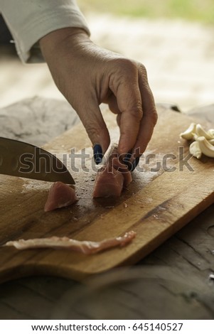 woman cut a slice of raw goat