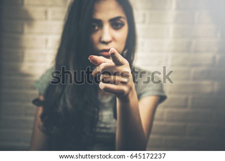 Young beautiful woman pointing finger on you looking