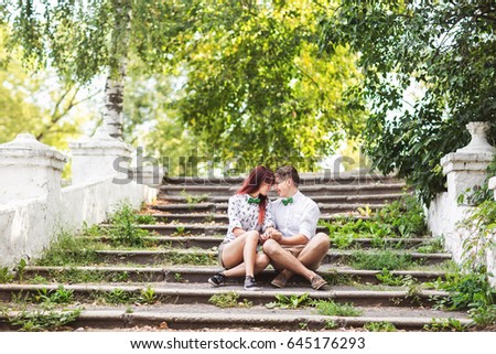 Couple in love sitting on stairs in park.