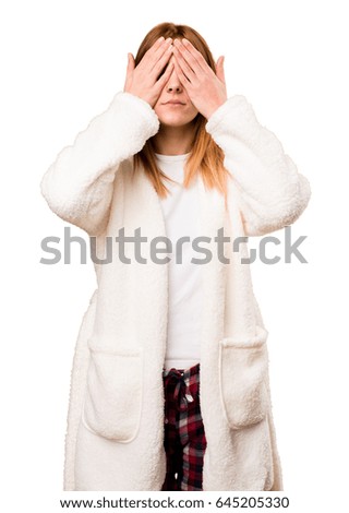 Young woman in dressing gown covering her eyes