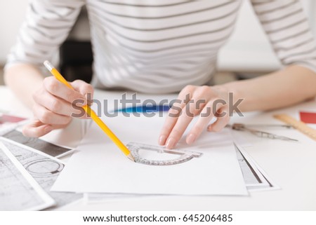 Skillful female engineer using a protractor